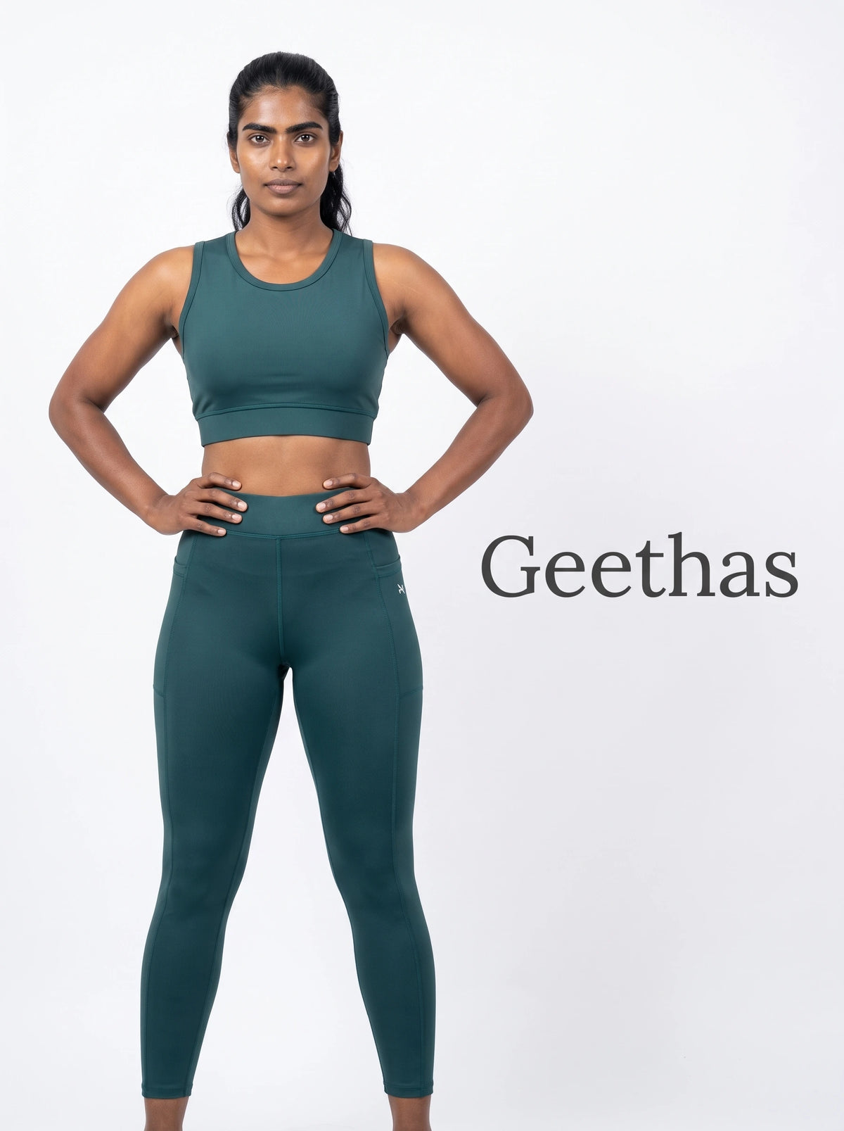 Model wearing teal blue sleeveless cropped activewear top and high-waisted leggings
