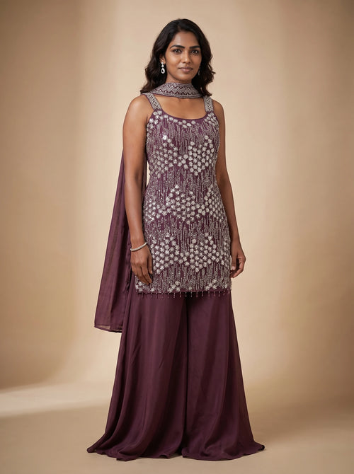 Model wearing a burgundy georgette sharara set with floral-inspired sequin and bead embellished top and matching dupatta
