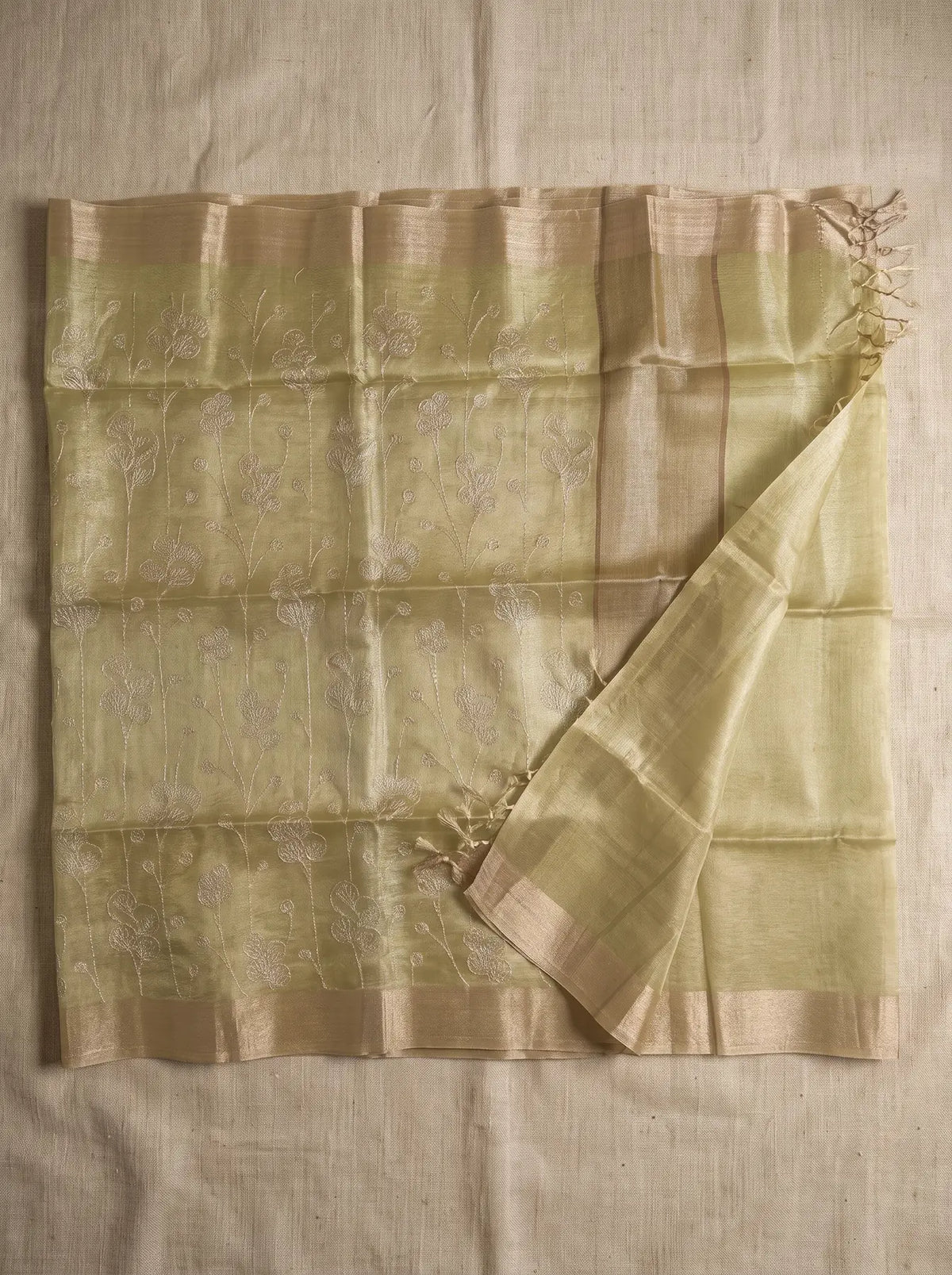 Pista green kota tissue saree displayed flat with floral zari embroidery, contrasting border and tassled pallu
