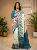 Model wearing an ivory white and teal blue printed slub linen saree with floral and elephant motifs