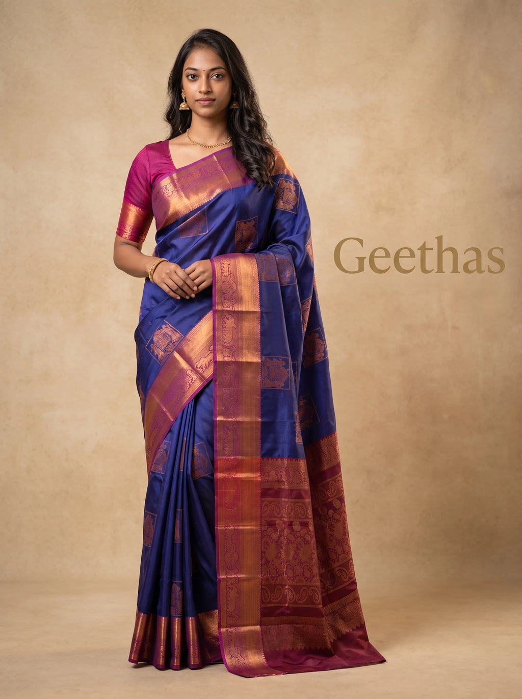 Model wearing a royal blue semi silk saree with copper-toned woven motifs and magenta pallu border
