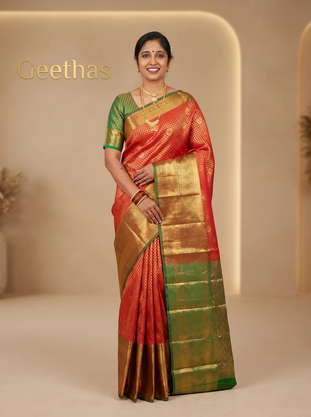 Model wearing vermilion orange ready-to-wear semi silk saree with woven motifs, gold-toned border and green edging