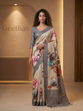 Model wearing a beige semi tussar saree with multicolour floral prints and a grey striped border