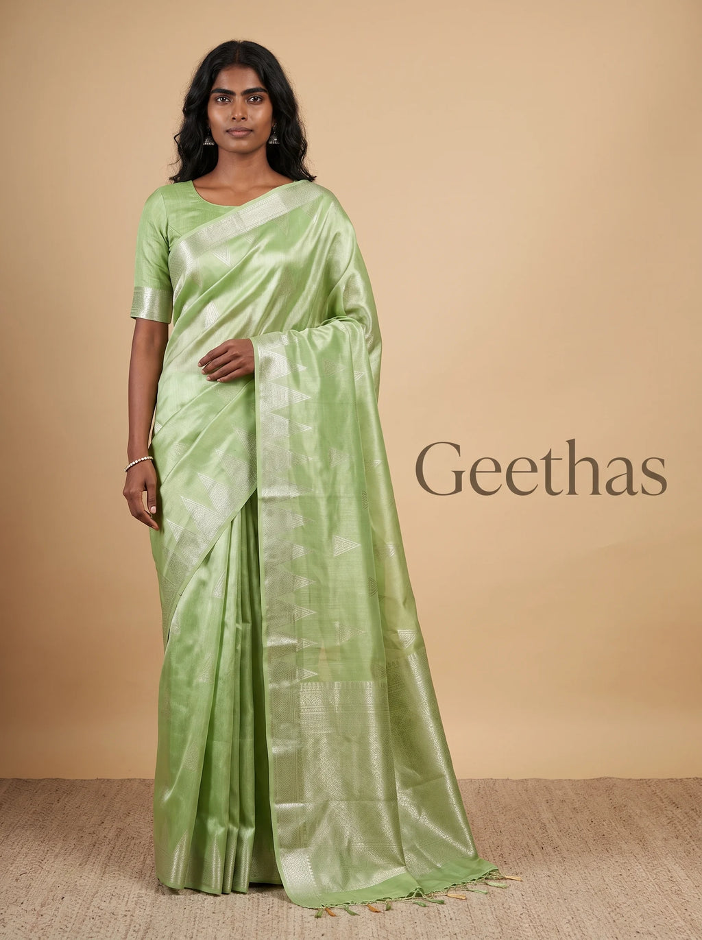 Model wearing pista green ready to wear soft tissue saree with woven geometric motifs and decorative border