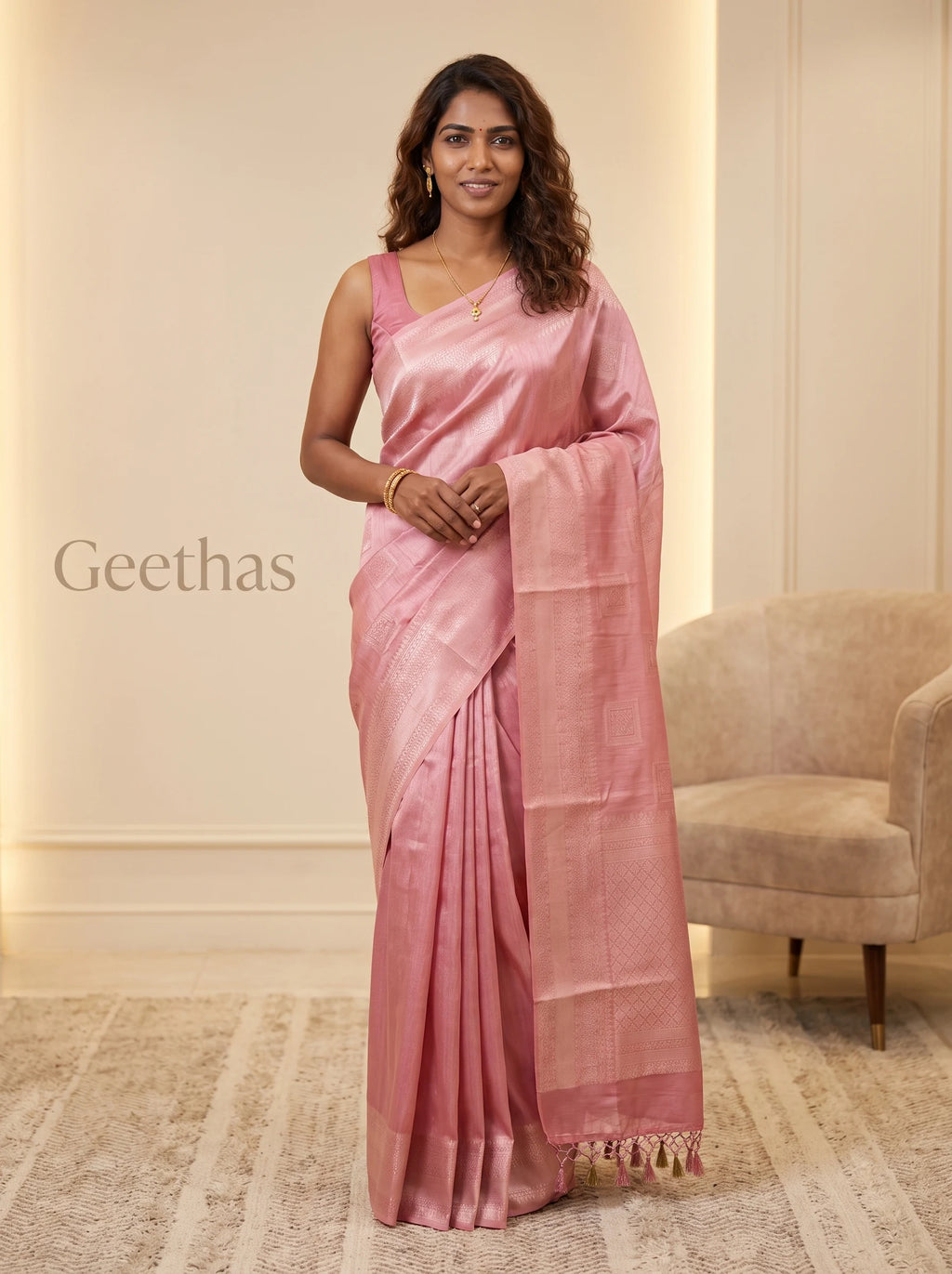 Model wearing pastel pink ready-to-wear soft tissue saree with woven motifs, patterned border and tassled pallu