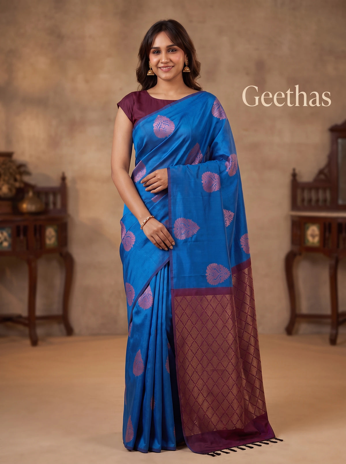 Model wearing a royal blue soft silk saree with mauve floral motifs and a plum geometric pallu