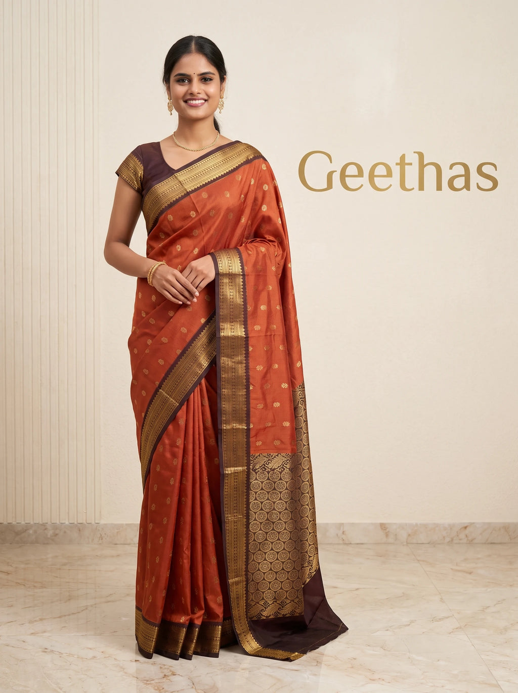 Model wearing rust orange soft silk saree with gold-toned motifs and contrasting deep brown zari border