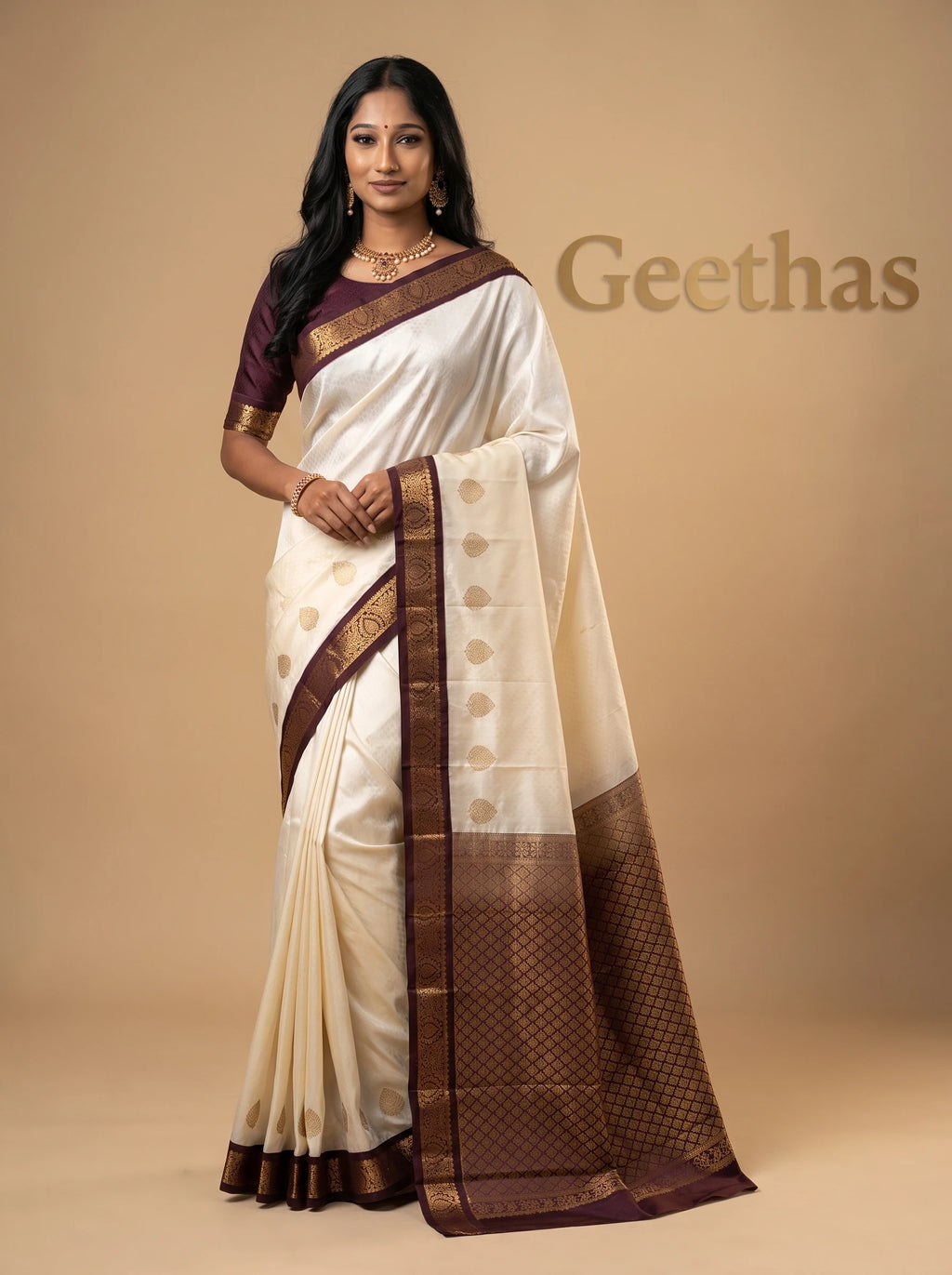 Model wearing half white soft silk saree with deep brown woven zari border and patterned pallu
