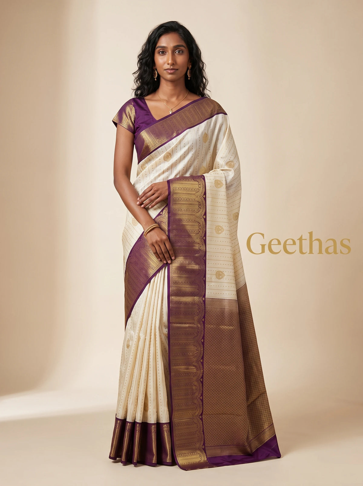 Model wearing a cream soft silk saree with gold-toned motifs and a purple woven border