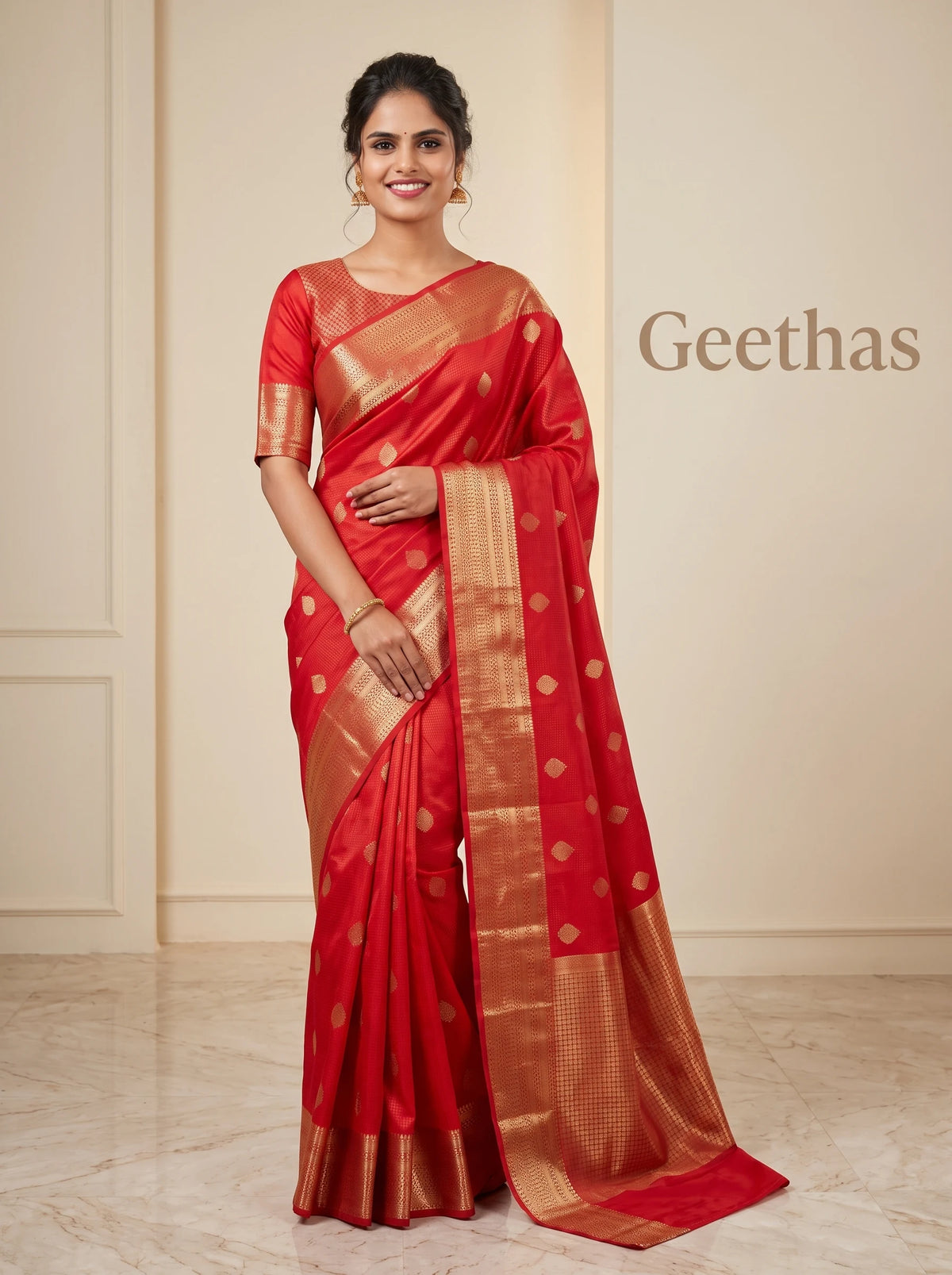 Model wearing a red soft silk saree with gold-toned woven motifs and an intricate zari border