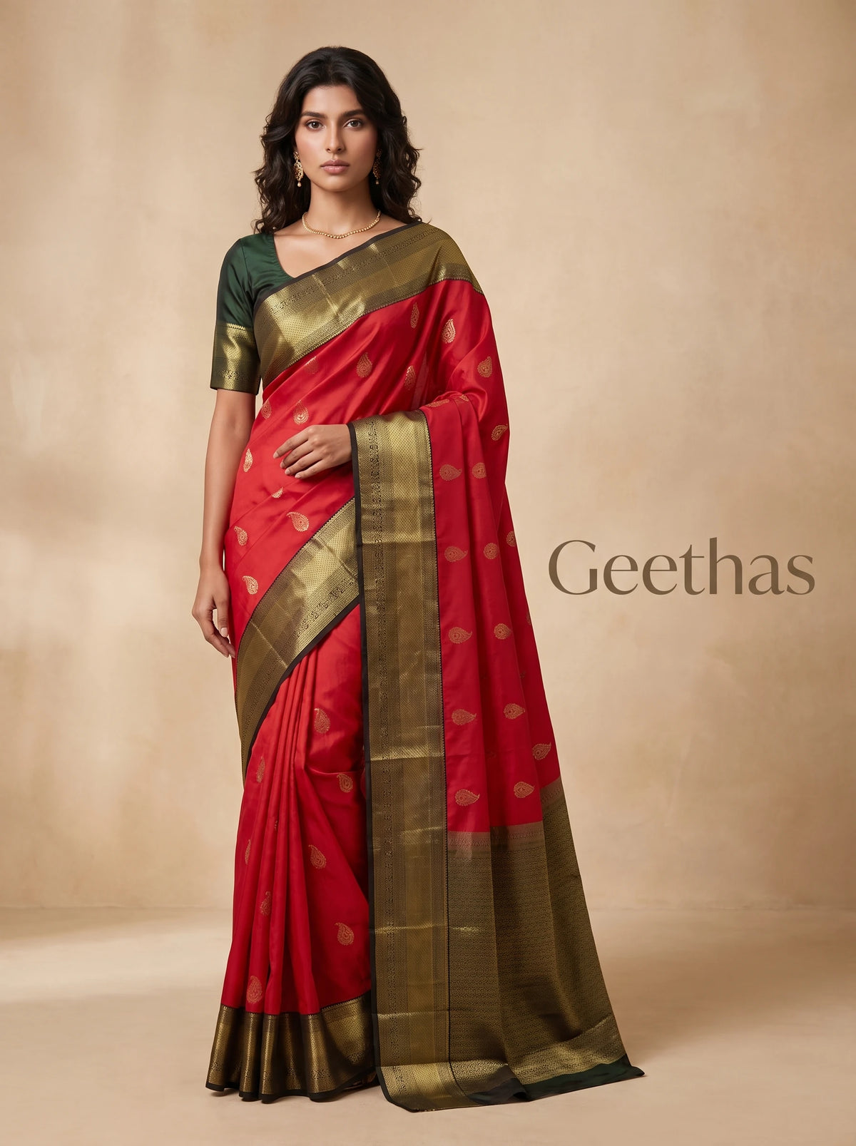 Model wearing pinkish red soft silk saree with gold-tone paisley motifs and a broad zari pallu border